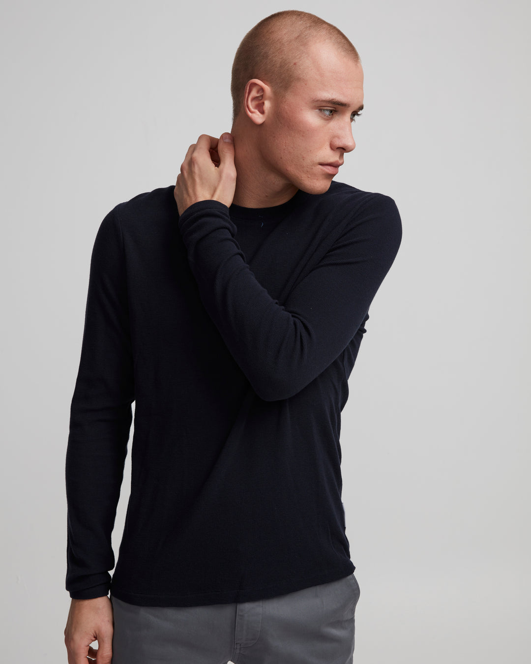 A male model wearing a black long sleeve waffle knit tee with ribbed binding, from the NN07 Clive 3323 collection.